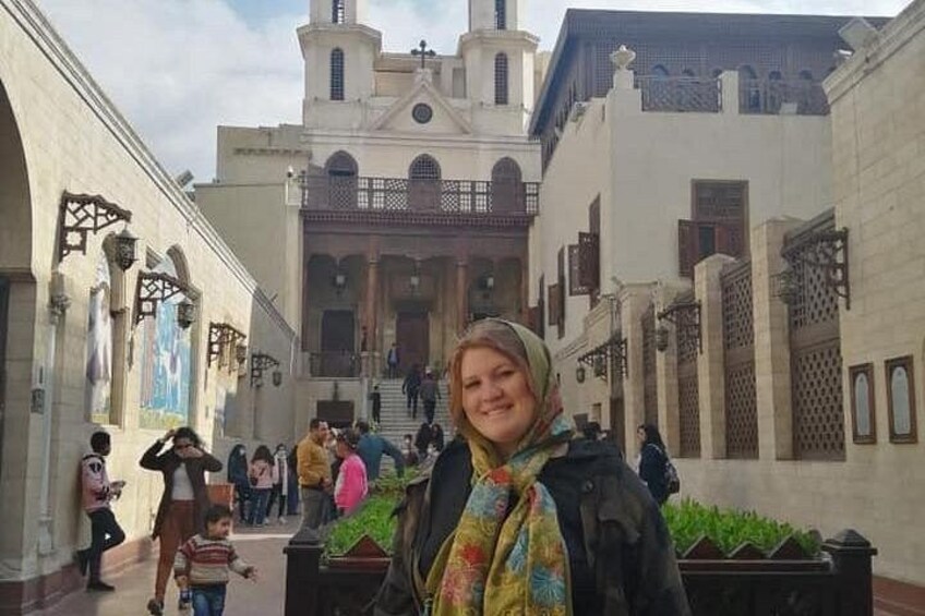 Une femme se tient dans une cour, avec un bâtiment en arrière-plan. 3