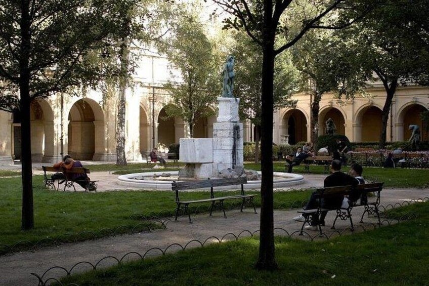 Un parc avec des bancs, une statue et une fontaine. 4