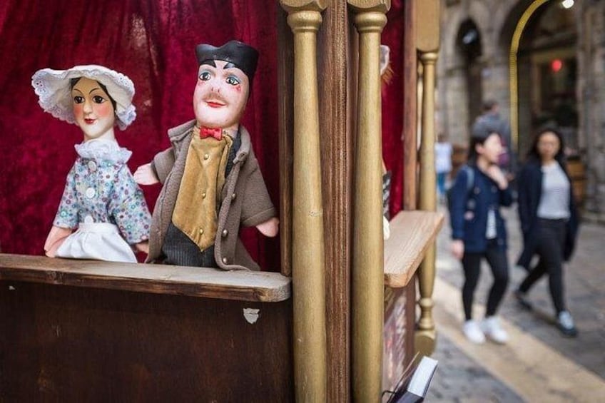 Un théâtre de marionnettes avec un rideau rouge en arrière-plan et un banc en bois. 3