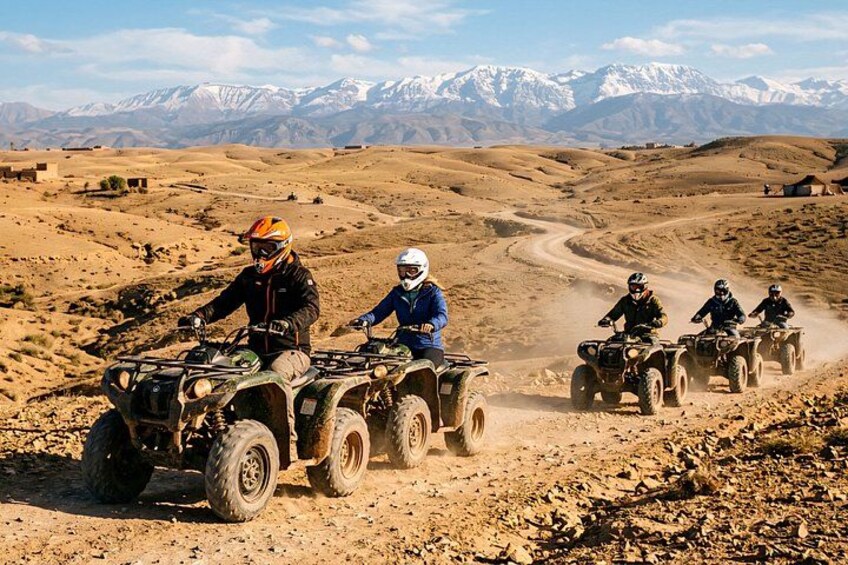 Un groupe de personnes circulant en quads sur un chemin de terre, avec un paysage montagneux en arrière-plan. 2