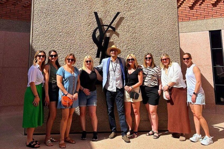 A group of people standing in front of a building with a large black sculpture. 3