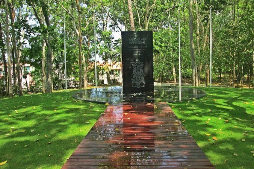 A memorial with a reflective walkway surrounded by trees. 5