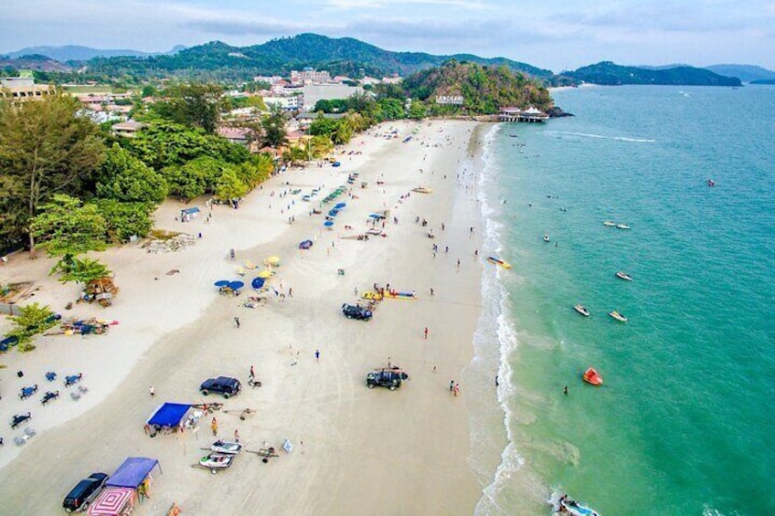 A beach with people, boats, and umbrellas. 2