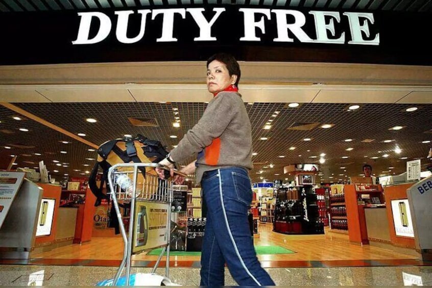 A person pushing a shopping cart in a store with a 'DUTY FREE' sign above. 4