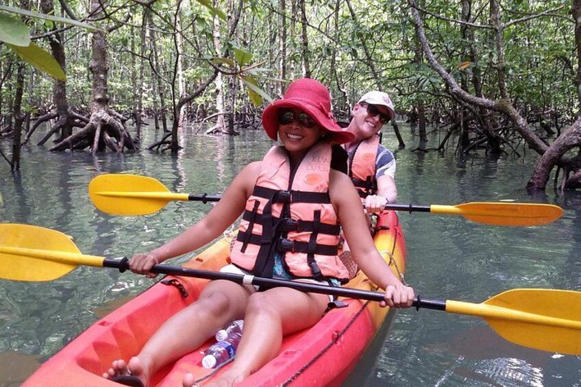 Two people kayaking in a mangrove forest. 4