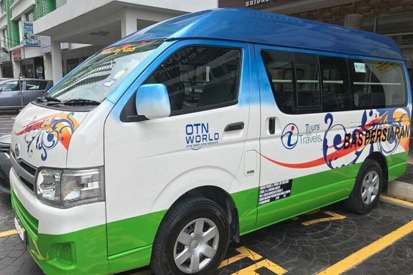 A colorful van with 'OTN WORLD' and 'Tours Travels' branding, parked on a city street. 2
