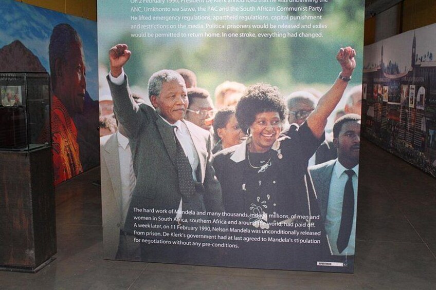 A historical exhibit with a photograph of Nelson Mandela and other figures, accompanied by text about his release and the end of apartheid. 4