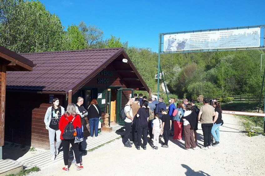 A wooden structure labeled 'VENIIN SHOP' with people gathered outside. 2