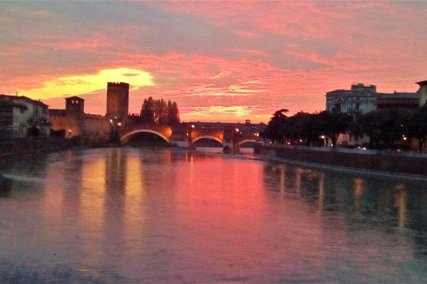 A sunset over a river with bridges and buildings reflecting on the water. 4