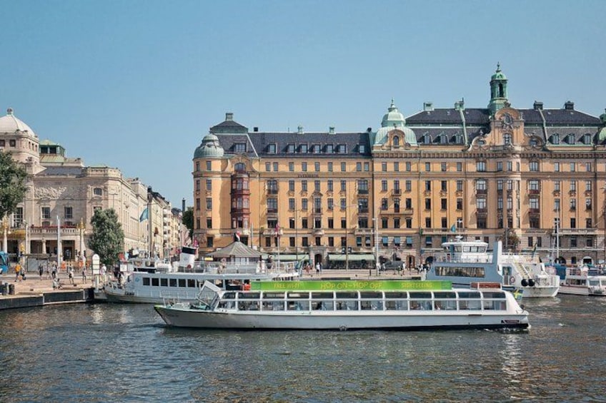 Une rivière avec un bateau, un grand bâtiment historique et un ciel dégagé. 4