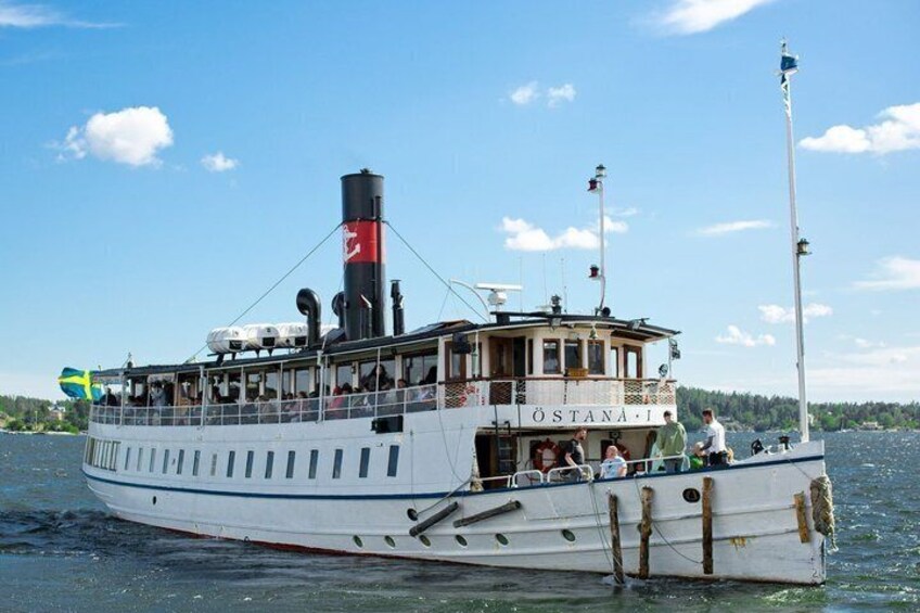 A white paddle steamer named 'OSTANA I' with a red funnel, passengers on deck, and a clear blue sky. 5