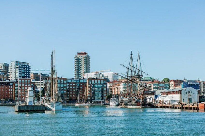 A harbor with a tall building, a sailboat, and a dock. 2
