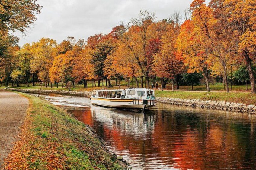 Un bote en un canal rodeado de árboles de colores otoñales. 1