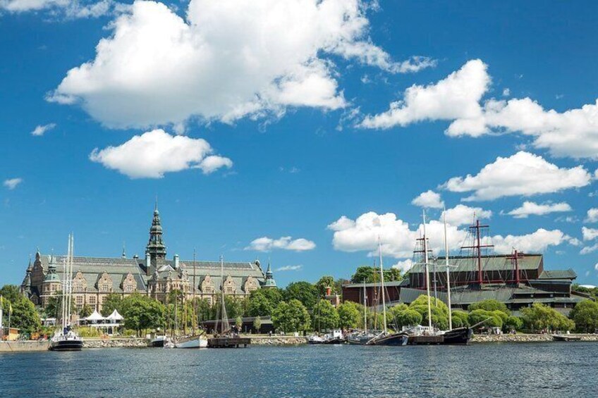 Ein Ufer mit einem großen Gebäude, Booten und blauem Himmel. 3