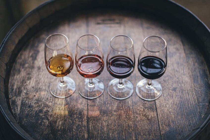 Quatre verres à vin posés sur un tonneau en bois. 2