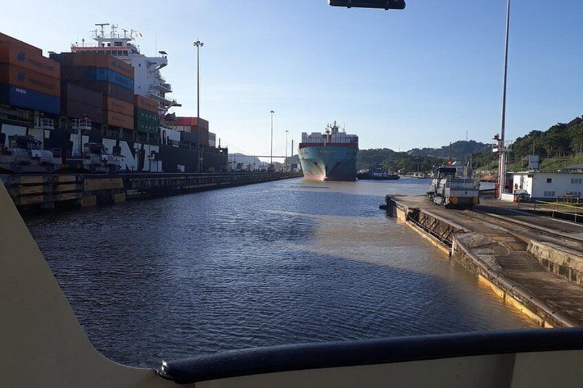 Et stort fragtskib ligger ved kaj i en havn med containere stablet på kajen. 4