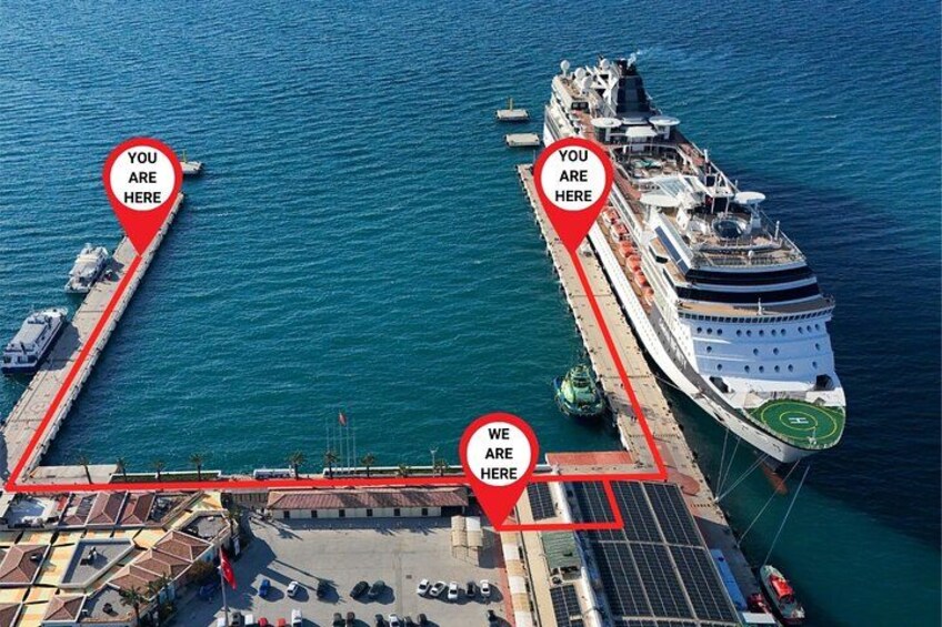 A cruise ship docked at a port with two red location markers indicating 'YOU ARE HERE' and 'WE ARE HERE'. 2
