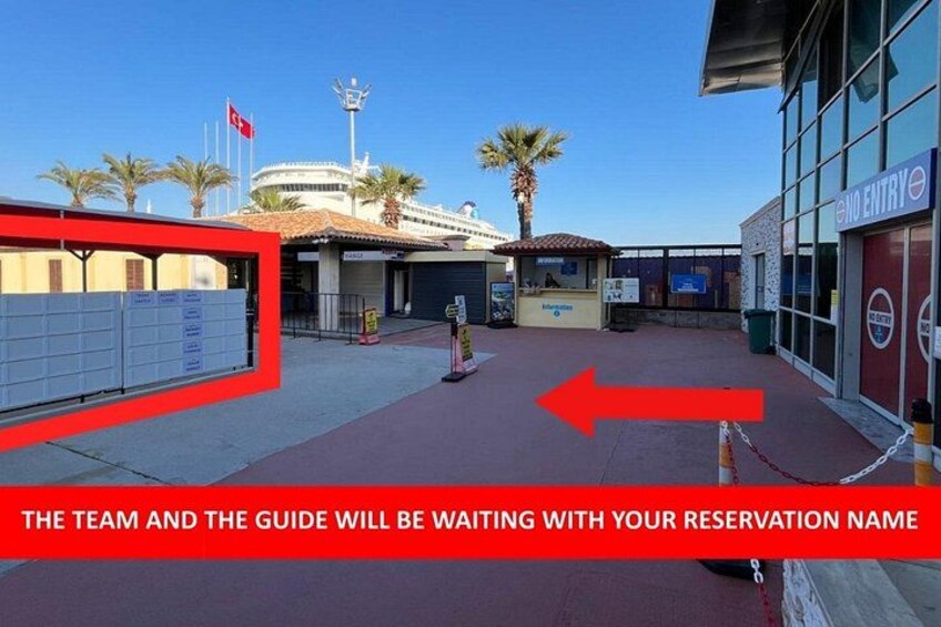 A building with a red sign indicating no entry. There is a fenced area with a gate, and palm trees in the background. 3