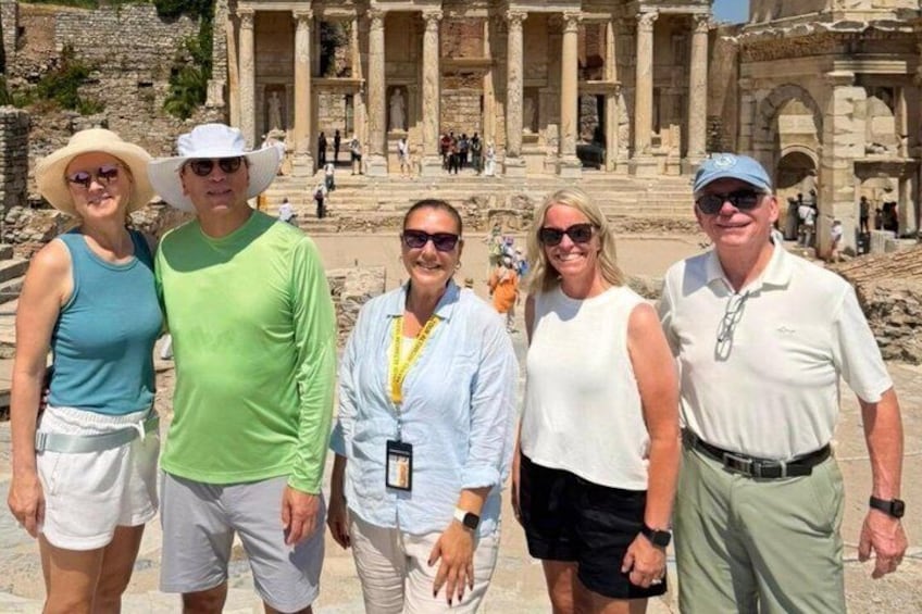 A group of people standing in front of an ancient ruin with columns and steps. 2