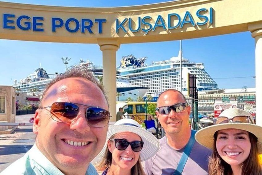 A group of people in front of a cruise ship with the sign 'EGE PORT KUSADASı' above them. 5
