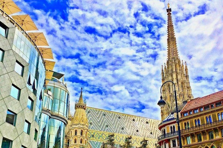 En katedral med ett högt torn, en modern byggnad med glasfasad och ett tak med ett dekorativt mönster. 2