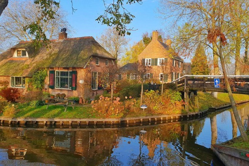 Un canal bordé de maisons, un pont en bois et le reflet des bâtiments dans l’eau. 2