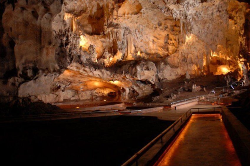 A cave with stalactites and a viewing platform. 2