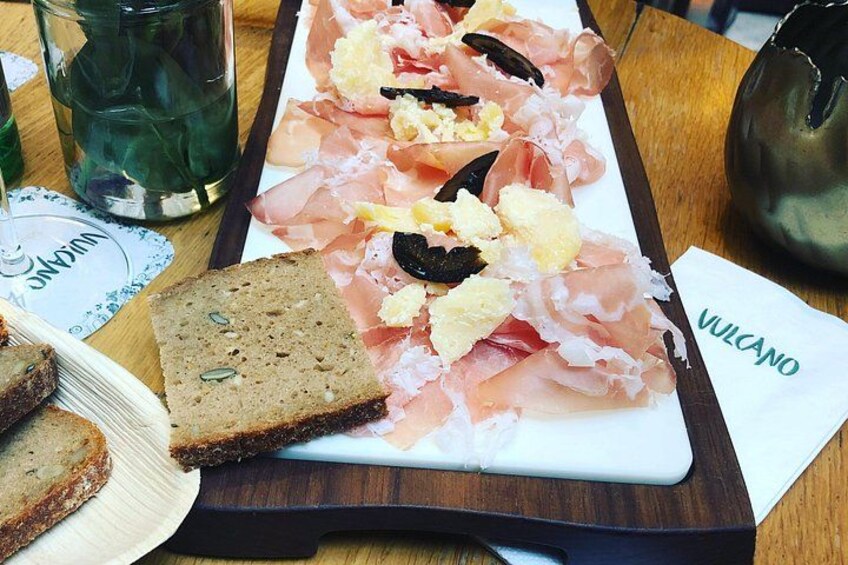 Un vassoio con prosciutto, uova e pane su un tavolo di legno. 5