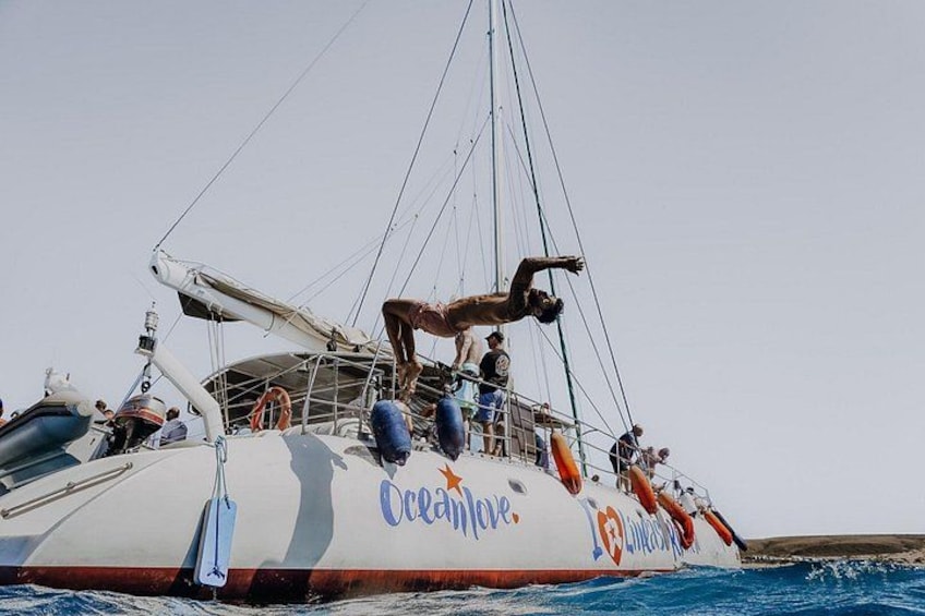 Eine Person macht einen Rückwärtssalto auf einem Boot namens 'Oceanlove'. 2