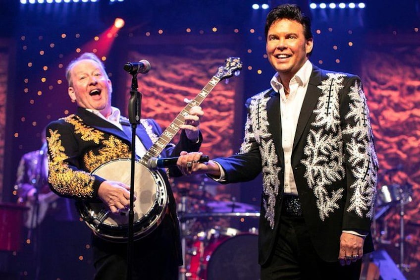 Two musicians performing on stage with musical instruments. 3
