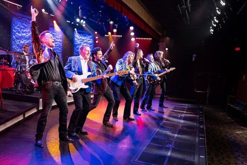 A band performing on stage with a drummer and a keyboard player. 5