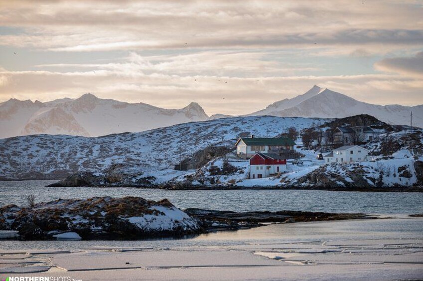A snowy landscape with a red house and a mountain in the background. 3