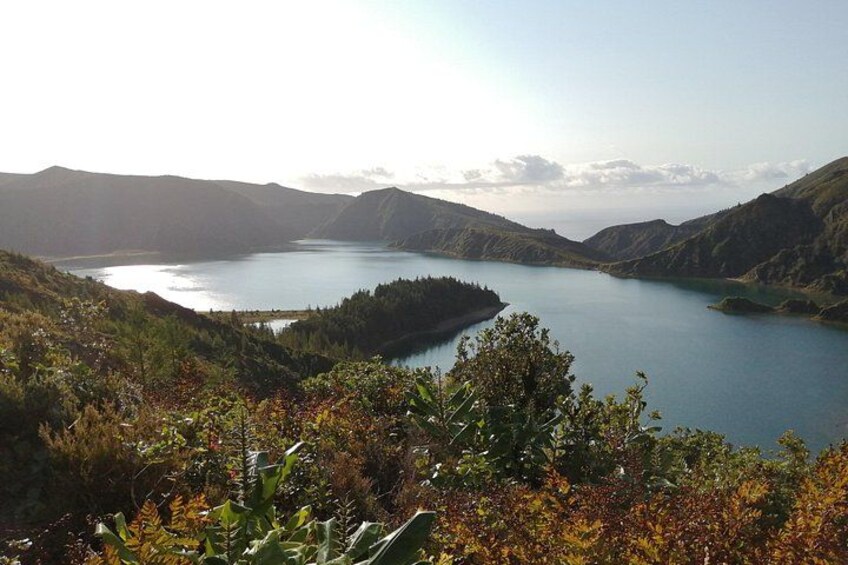 A lake surrounded by hills, with vegetation in the foreground. 3