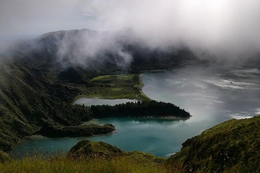 A mountainous landscape with a lake surrounded by forested areas. 2