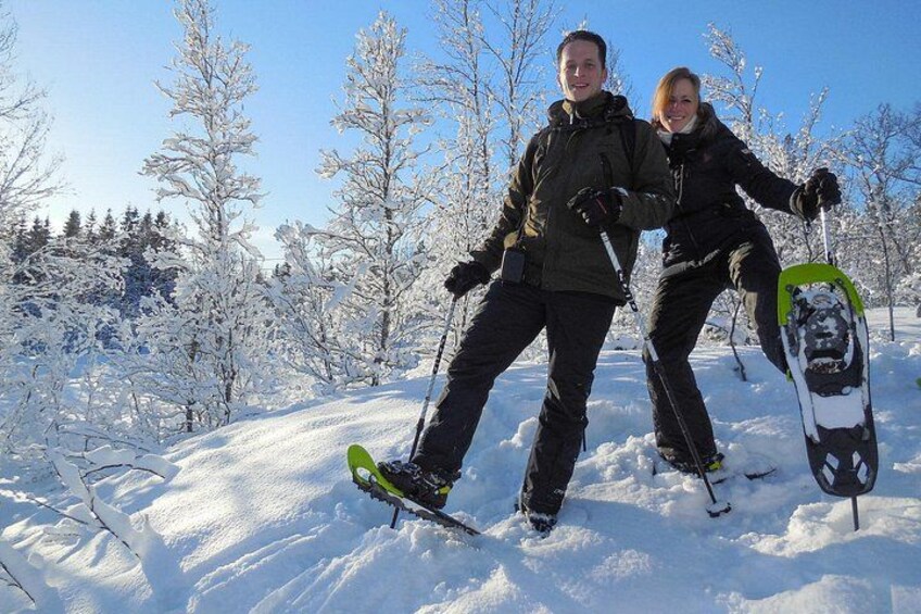Twee mensen skiën door een besneeuwd bos. 1