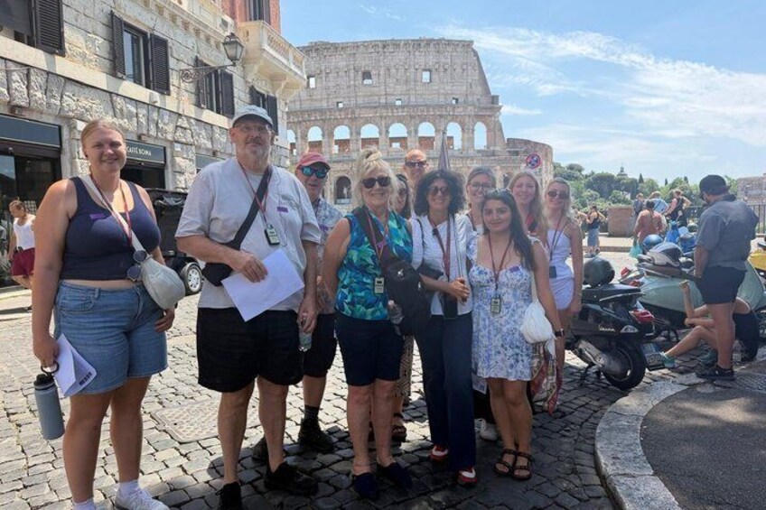 Un groupe de personnes se tient devant le Colisée à Rome. 2