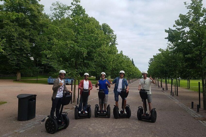 Four people on segways on a tree-lined path. 2