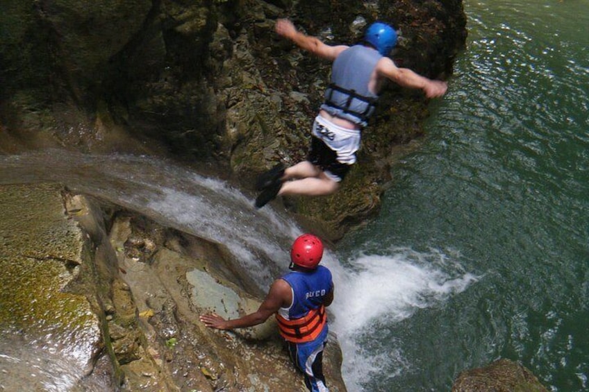 Deux personnes descendent en rappel le long d’une falaise rocheuse pour atterrir dans une étendue d’eau. 2