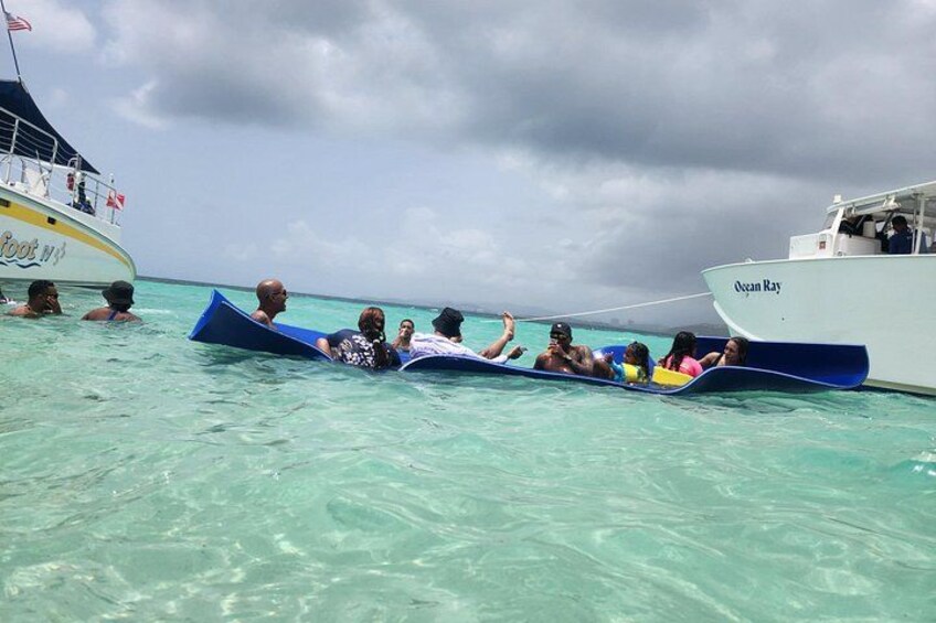People on a boat in clear turquoise water, with another boat named 'Ocean Ray' in the background. 4