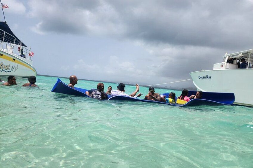 People on a boat in clear turquoise water, with another boat named 'Ocean Ray' in the background. 4