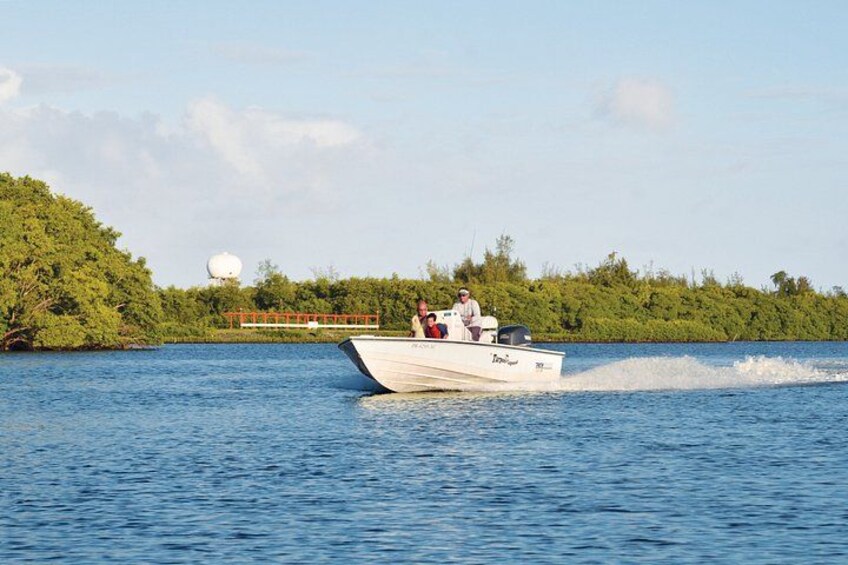 A speedboat on a body of water with a forested island in the background. 2