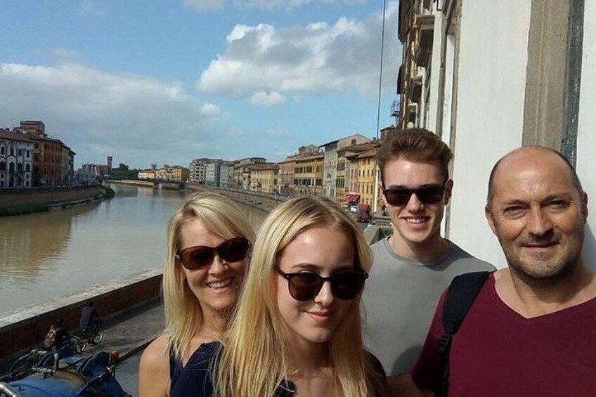 A group of people standing by a river with buildings in the background. 4