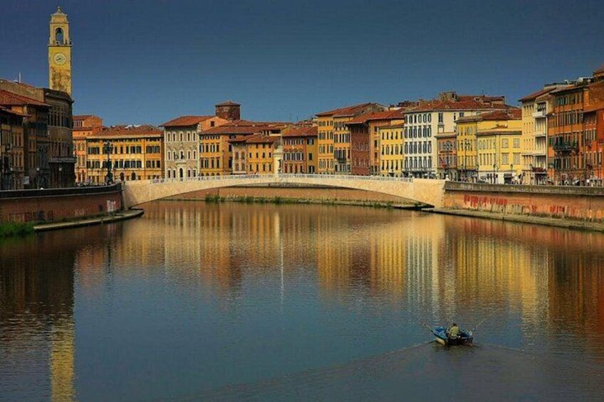 Un fiume tranquillo con un ponte, edifici storici e una torre dell'orologio. 2