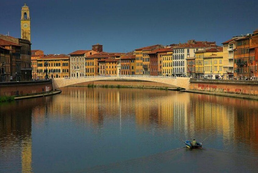 A calm river with a bridge, colorful buildings, and a clock tower. 2