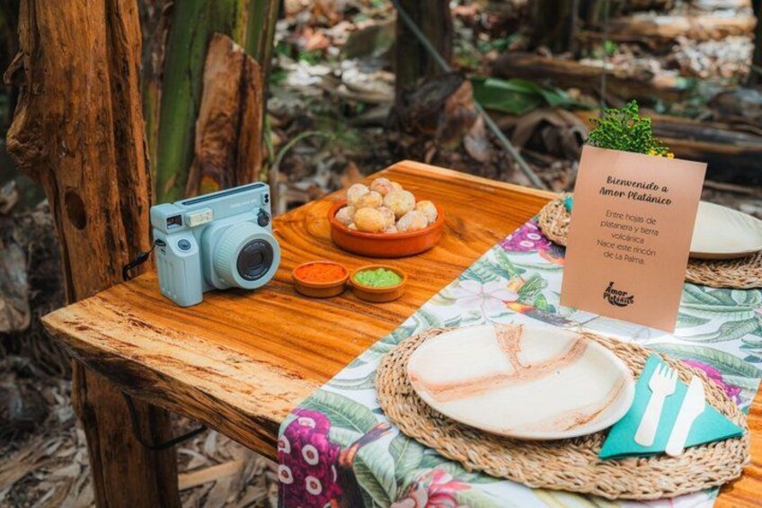 A rustic wooden table with a vintage camera, a plate of food, and a welcome sign. 5
