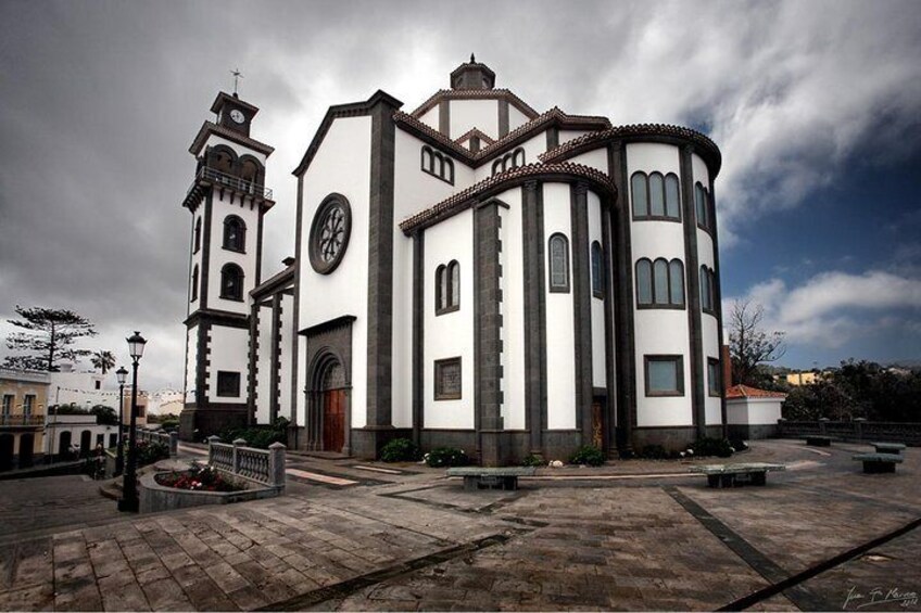 Una iglesia con una torre del reloj y un ventanal circular. 4