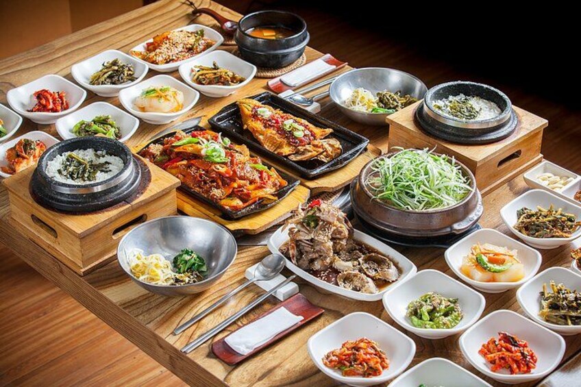 A variety of Korean dishes arranged on a wooden table. 2