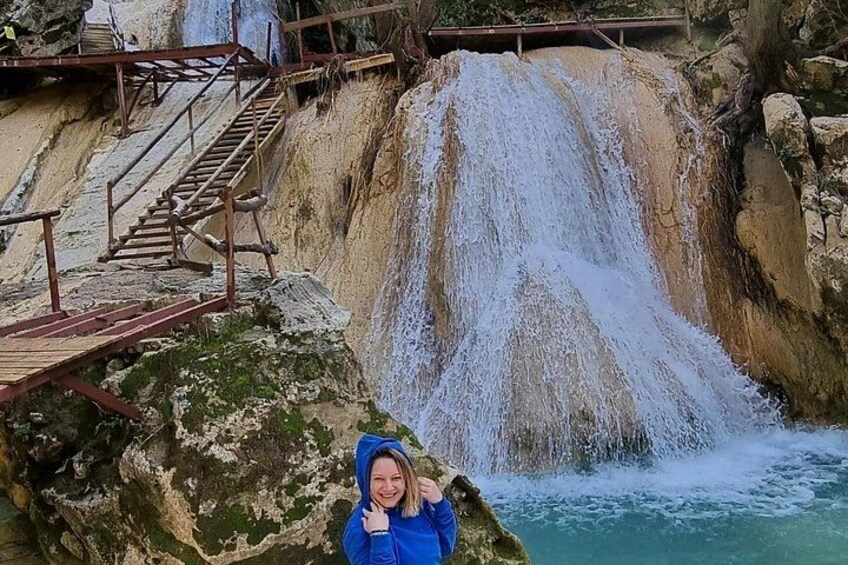 Een waterval, een houten trap en een persoon in een blauw jack. 3