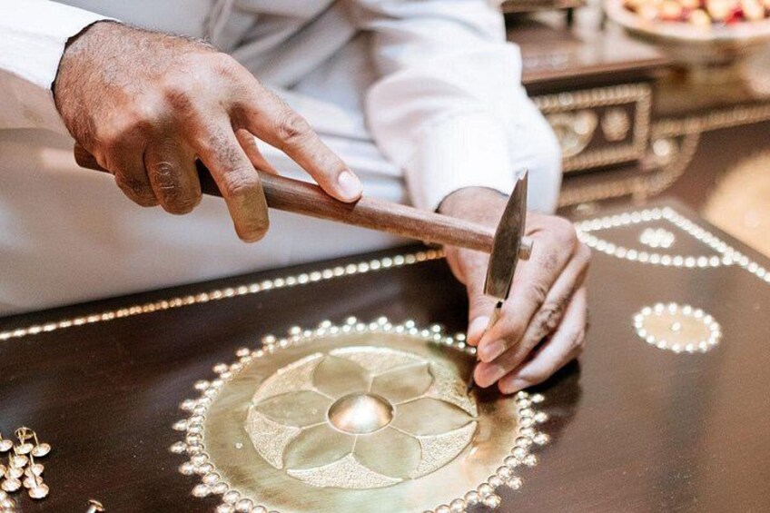A person engraving a design into a wooden surface. 3