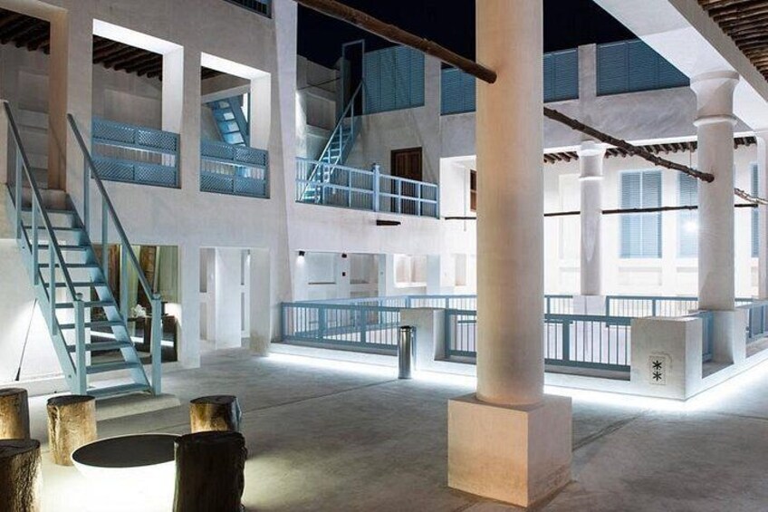 An interior courtyard with concrete pillars, a staircase, and a blue railing. 5